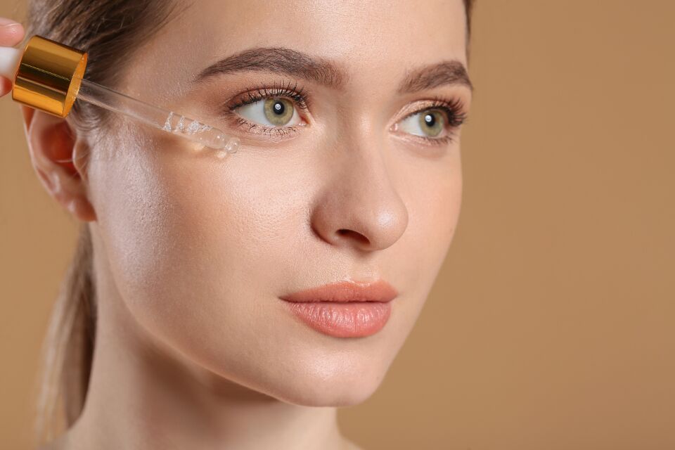 Serum dropper applied to the cheek as part of a skin treatment facial