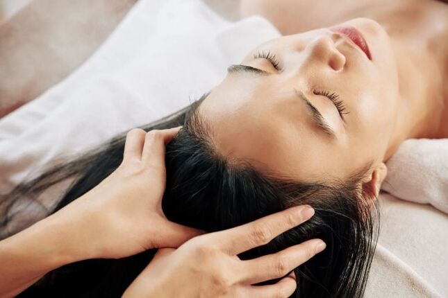 Therapist giving a Chinese herbal head spa scalp massage at a Huntington Long Island spa