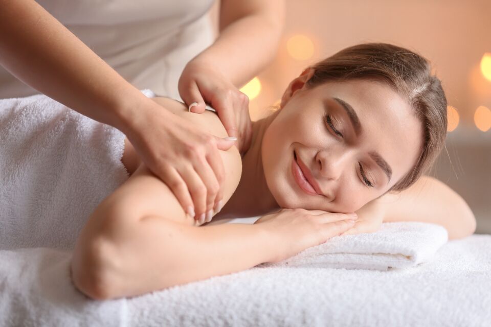 Guest receiving shoulder body work with CBD oil at a Long Island spa