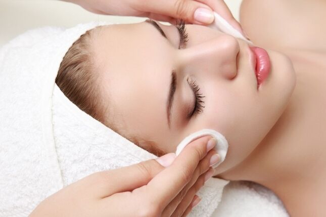 Esthetician gently cleansing a guest's skin with cotton pads during a signature facial in Huntington NY